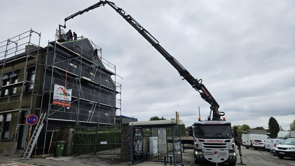 Photo d'un camion de manutention de l'entreprise Lejoly-Pothen avec grue déployée