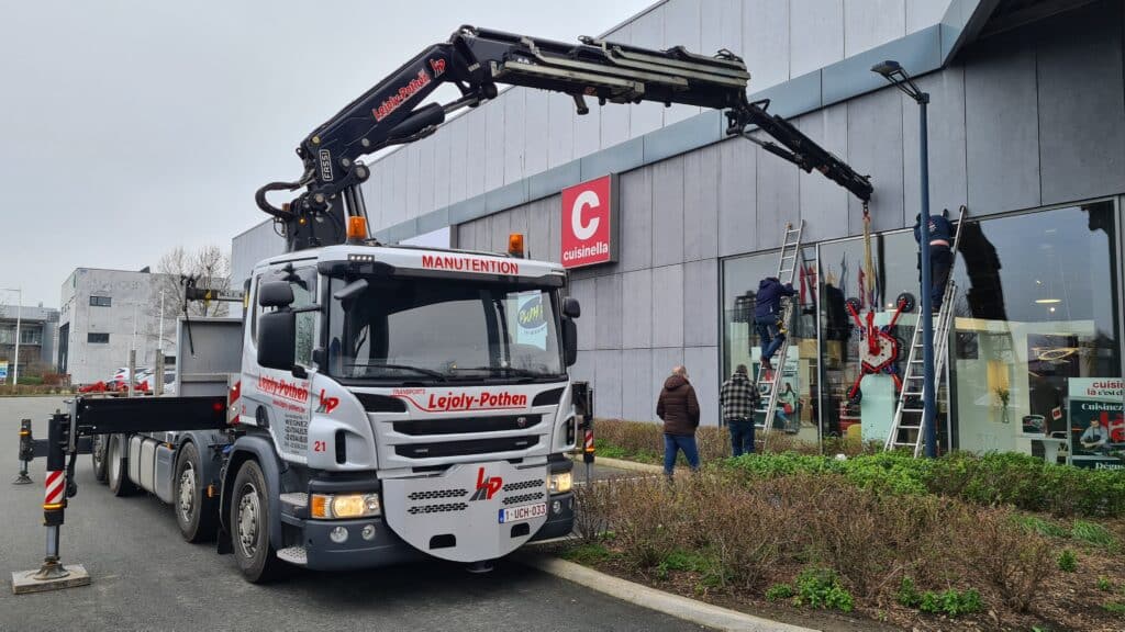 Photo d'un camion de manutention de l'entreprise Lejoly-Pothen avec grue pour placement de vitrage